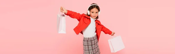 Stijlvol Meisje Hoofdtelefoon Houden Boodschappentassen Geïsoleerd Roze Banner — Stockfoto