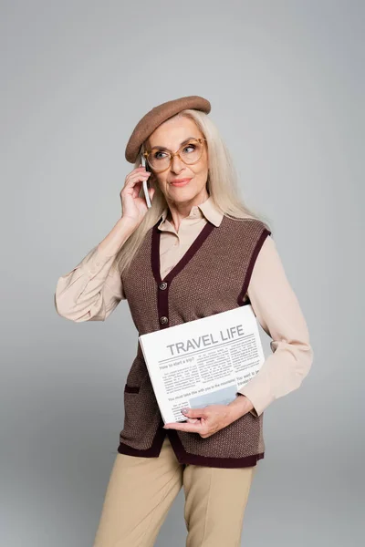 Stylish Senior Woman Talking Smartphone Holding Newspaper Isolated Grey — Stock Photo, Image