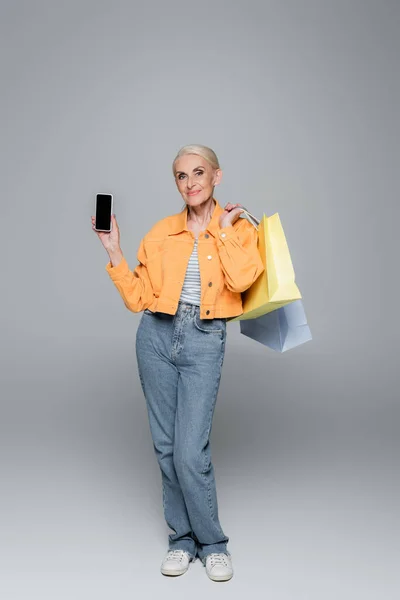 Positiva Anziana Donna Posa Con Shopping Bag Cellulare Grigio — Foto Stock