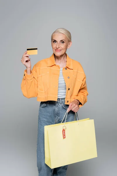 Smiling Senior Woman Shopping Bag Credit Card Looking Camera Grey — Stock Photo, Image