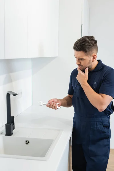 Thoughtful Handyman Holding Wrench Sink Kitchen — Stock Photo, Image
