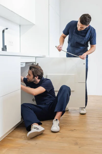 Werkman Met Metalen Slang Buurt Loodgieter Werken Vloer Keuken — Stockfoto