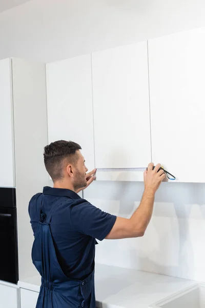 Handyman Overalls Measuring White Furniture Kitchen — Stock Photo, Image