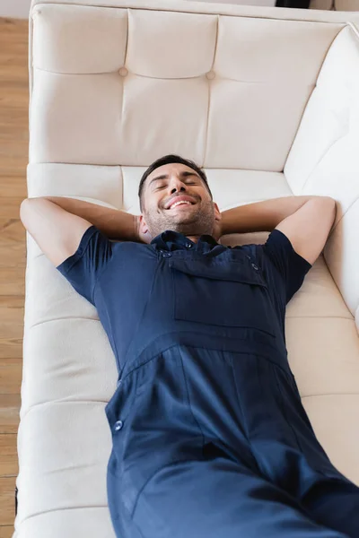 Trabalhador Feliz Macacão Relaxante Sofá Branco Com Olhos Fechados — Fotografia de Stock