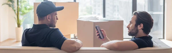 Mover Smartphone Talking Colleague While Sitting Sofa Carton Boxes Banner — Stock Photo, Image