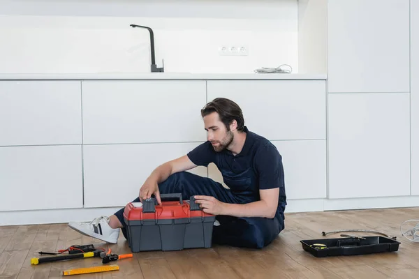 Joven Reparador Sentado Suelo Cocina Cerca Caja Herramientas Herramientas — Foto de Stock