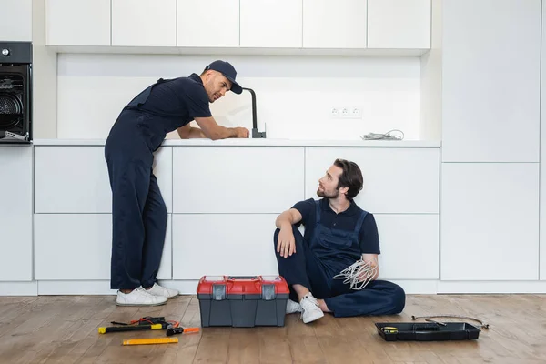 Fontanero Mirando Trabajador Sentado Piso Cocina Cerca Caja Herramientas Herramientas — Foto de Stock