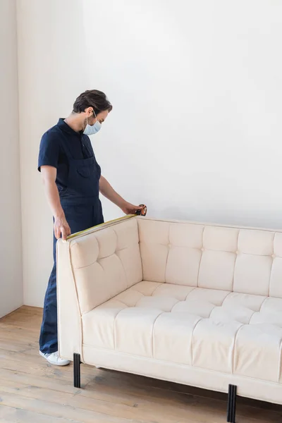 Mover Overalls Measuring White Couch Modern Apartment — Stock Photo, Image