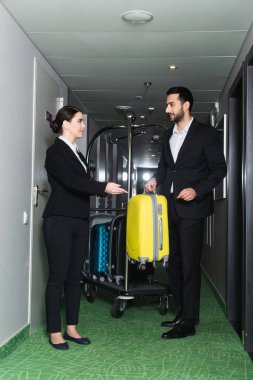Gülümseyen resepsiyonist valizli bellboy 'un elini gösterdi. 