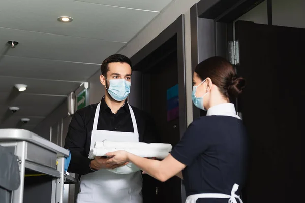 Szobalány Orvosi Maszkban Tiszta Ágyneműt Házvezetőnőnek Kocsi Közelében — Stock Fotó