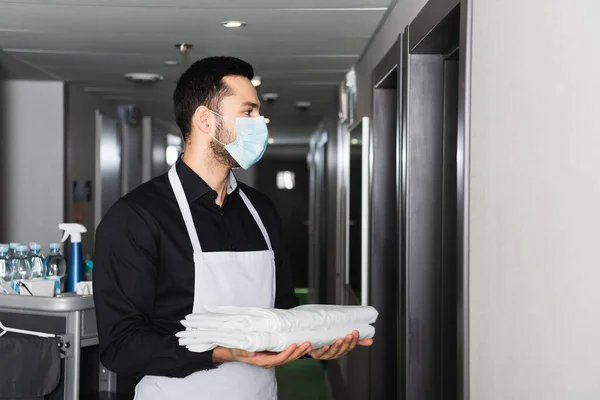 Housekeeper Medical Mask Holding Clean Bed Sheets Corridor Hotel — Stock Photo, Image