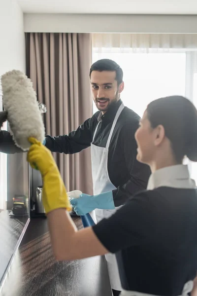 Cheerful Housekeeper Rubber Gloves Looking Blurred Chambermaid Dust Brush Cleaning — Stock Photo, Image