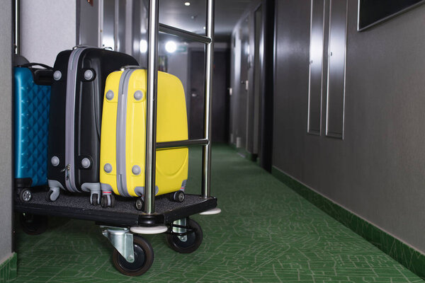 modern luggage on bell cart in hotel hall 