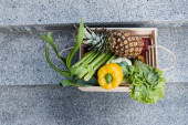 Horní pohled na čerstvé ovoce a zeleninu v dřevěné krabici na schodech 