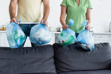 Mutfakta çöp torbası tutan çift görüntüsü. 
