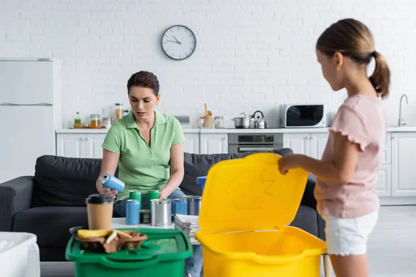 Kvinna Sortera Burkar Nära Suddig Dotter Och Papperskorgar Hemma — Stockfoto