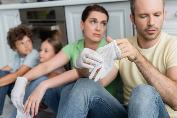 Man Met Latex Handschoen Buurt Wazig Familie Keuken — Stockfoto