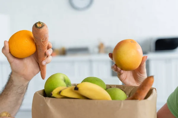 Cropped View Couple Holding Fruits Paper Bag Kitchen — Stock Photo, Image