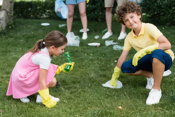 Smiling Boy Rubber Gloves Looking Camera Garbage Lawn Family Outdoors — Stock Photo, Image