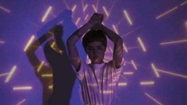 Soyut mor arka planda dans eden beyaz elbiseli dövmeli bir model. 