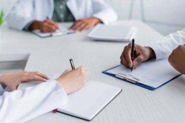 Toplantı odasında meclis sırasında çok ırklı doktorların yazışma görüşü