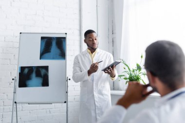 Afro-Amerikalı doktor akciğer röntgenleri ve bulanık meslektaşı