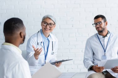 Görüşme sırasında gülümseyen Asyalı doktor, bulanık Afrikalı meslektaşını işaret etti