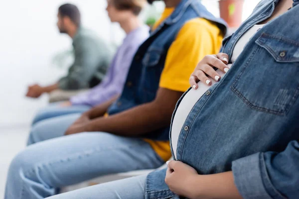 Ostříhaný Pohled Těhotné Ženy Dotýkající Břicha Při Sezení Frontě Rozmazanými — Stock fotografie
