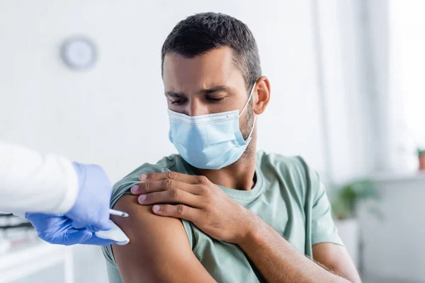 ラテックス手袋で看護師医療マスクの青年をワクチン接種 — ストック写真