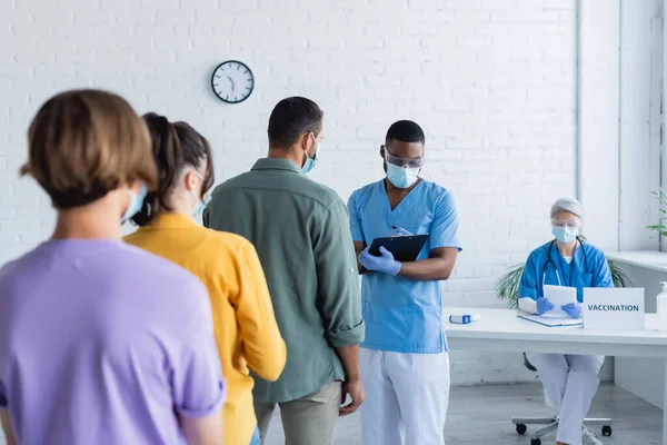 Back View Patients African American Doctor Writing Clipboard Vaccination Center — Stock Photo, Image