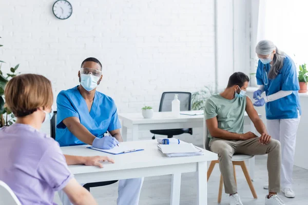 Rasblandat Läkare Medicinska Masker Och Enhetligt Arbete Med Unga Män — Stockfoto
