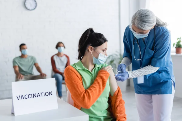 Enfermeira Amadurecida Que Injeção Mulher Nova Perto Vacinação Lettering Pacientes — Fotografia de Stock