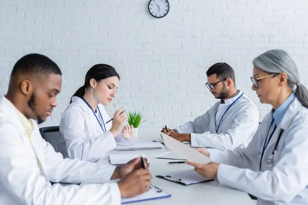 Medici Multiculturali Seduti Alla Scrivania Durante Consiglio Medico Clinica — Foto Stock