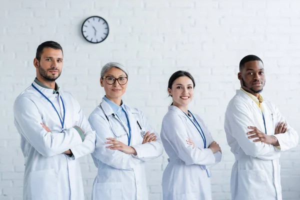 Médicos Multiculturales Felices Batas Blancas Pie Con Los Brazos Cruzados — Foto de Stock