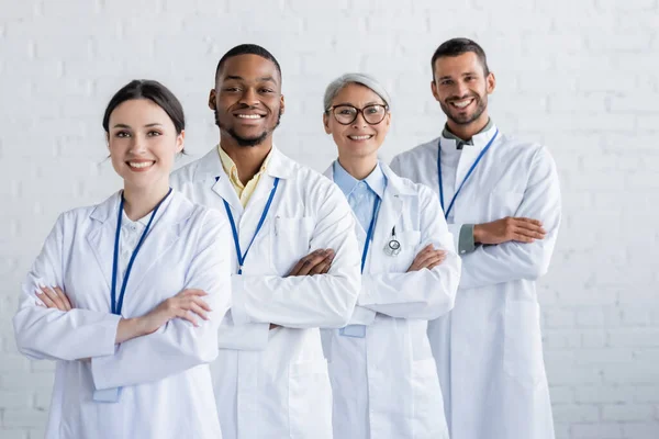 Веселі Багатоетнічні Лікарі Стоять Схрещеними Руками Посміхаються Камеру — стокове фото