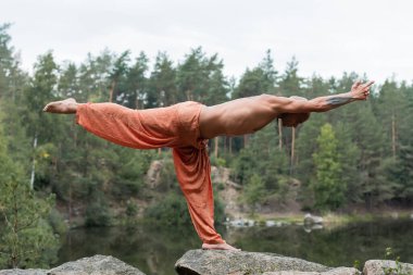 Yarım ayda meditasyon yapan üstsüz Budistlerin nehir üzerindeki kayalıklarda poz verişi.