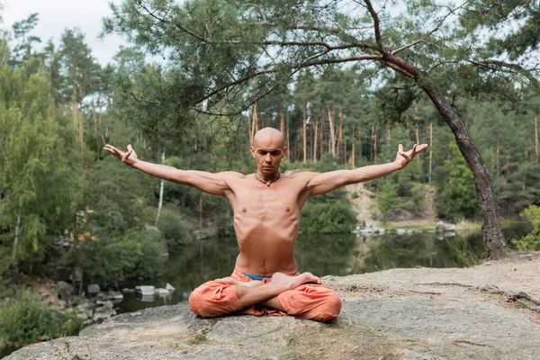 Shirtless Buddhist Meditating Lotus Pose Outstretched Hands Rocky Cliff Lake — Stock Photo, Image
