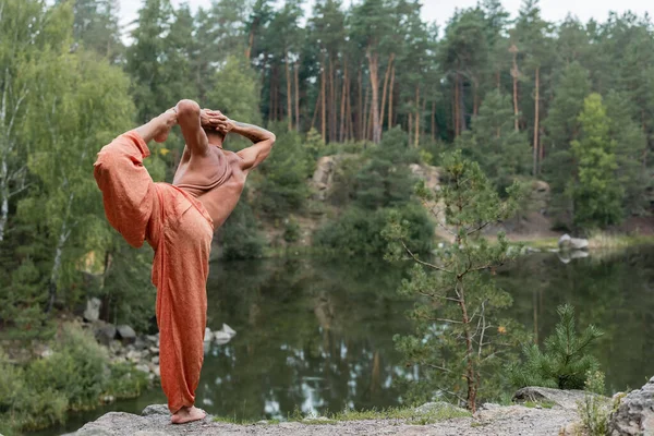 Back View Shirtless Buddhist Practicing Standing Bow Pose Rock Lake — Stock Photo, Image