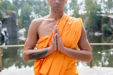 Açık havada dua eden ellerle meditasyon yapan dövmeli Budist manzarası.