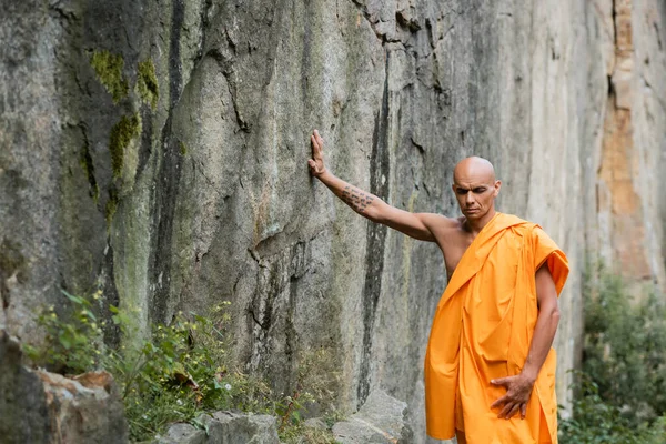 Bouddhiste Kasaya Orange Touchant Roche Tout Méditant Les Yeux Fermés — Photo