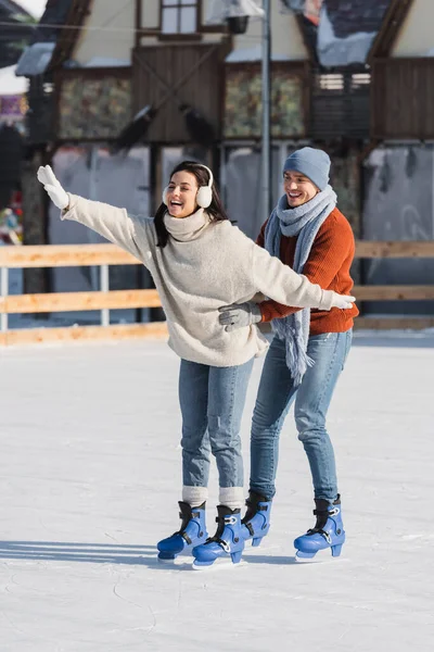 Full Length Happy Man Supporting Excited Woman Skating Ice Rink — Stock Photo, Image