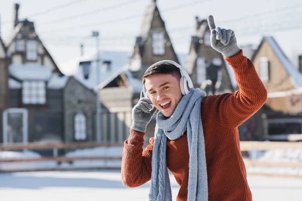 Happy Young Man Sweater Scarf Listening Music While Singing Pointing — Stock Photo, Image