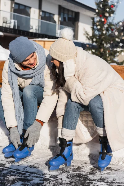 Boldog Fiatal Pár Téli Kalapban Padon Jégkorcsolyát Visel — Stock Fotó