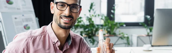 Cheerful Muslim Businessman Eyeglasses Holding Hand Sanitizer Office Banner — Stock Photo, Image