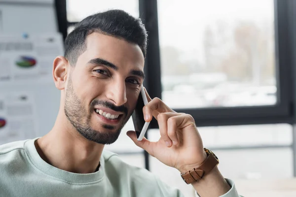 Mosolygó Muszlim Üzletember Beszél Okostelefonon Kamera Irodában — Stock Fotó