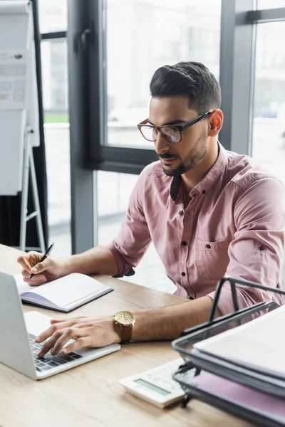 Joven Hombre Negocios Musulmán Gafas Usando Portátil Celebración Pluma Cerca — Foto de Stock