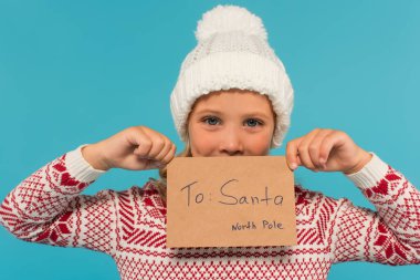 Örgü şapkalı çocuk elinde Noel Baba 'ya yazdığı mektupla mavi yüzlü yalnız.