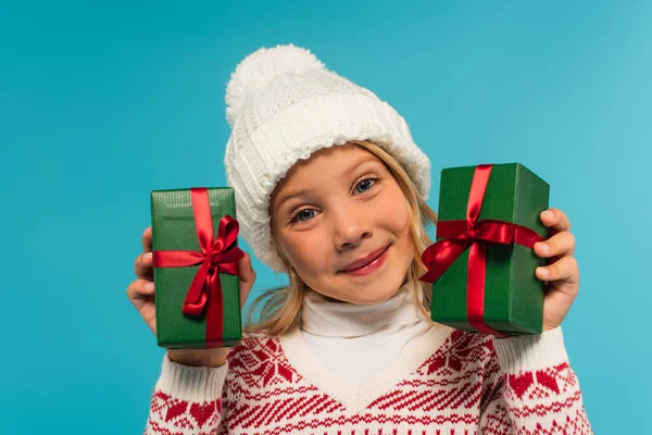 Довольная Девушка Вязаной Шляпе Держа Зеленые Подарочные Коробки Изолированы Синий — стоковое фото