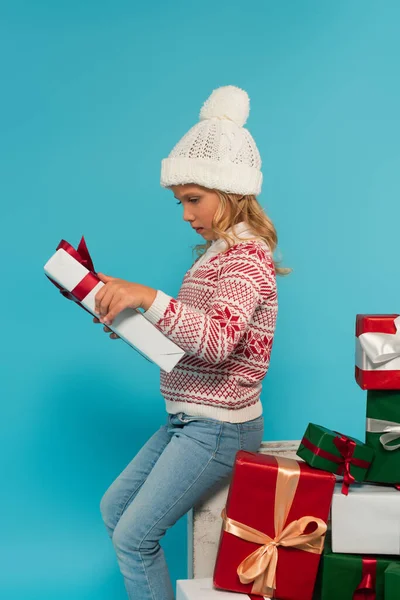 Kid Knitted Hat Warm Sweater Looking Presents Pile Gift Boxes — Stock Photo, Image