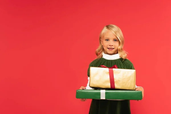 Alegre Chica Sonriendo Cámara Mientras Sostiene Regalos Aislados Rojo — Foto de Stock